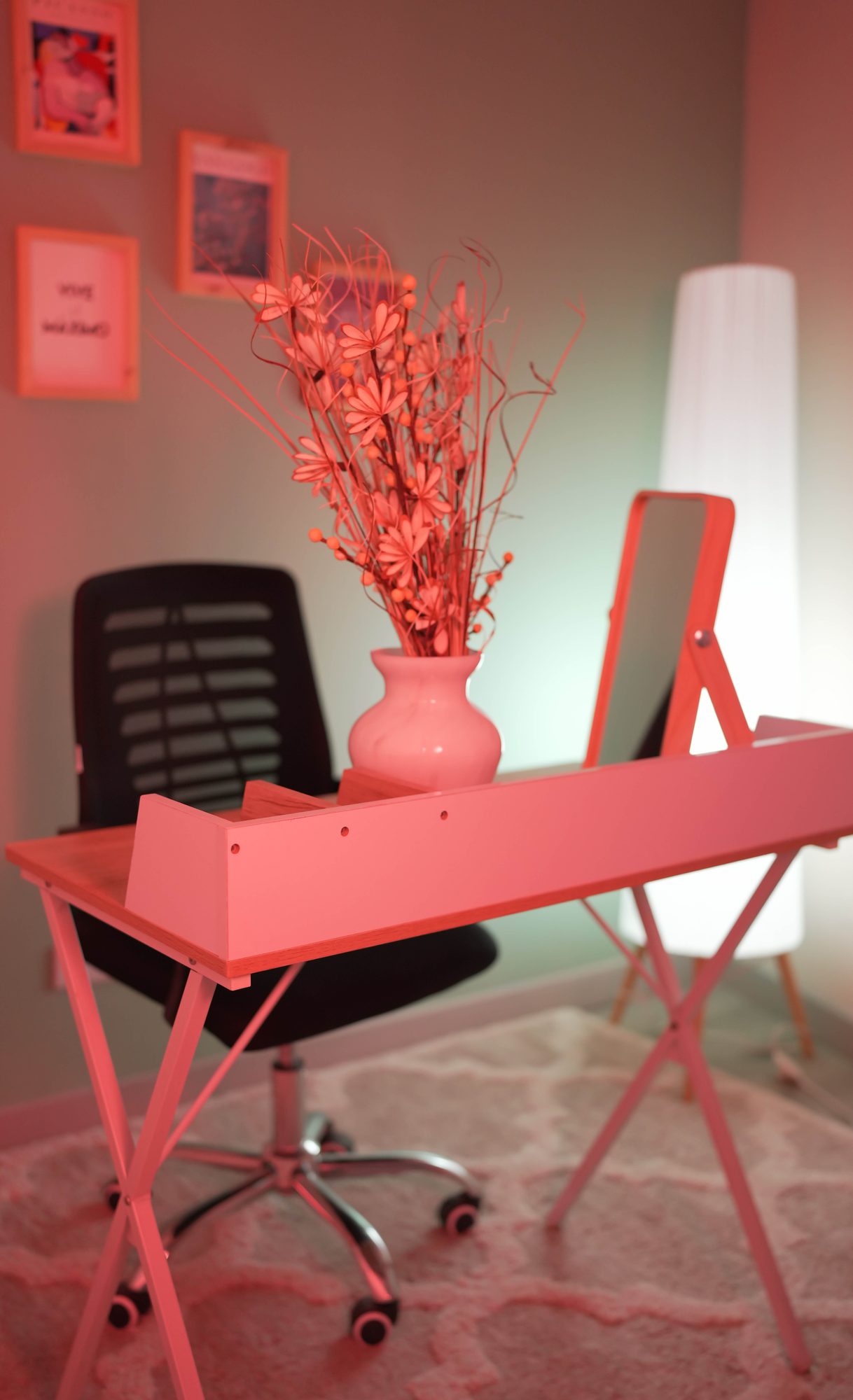 Escritorio de streaming rosa con laptop y pared de galería
