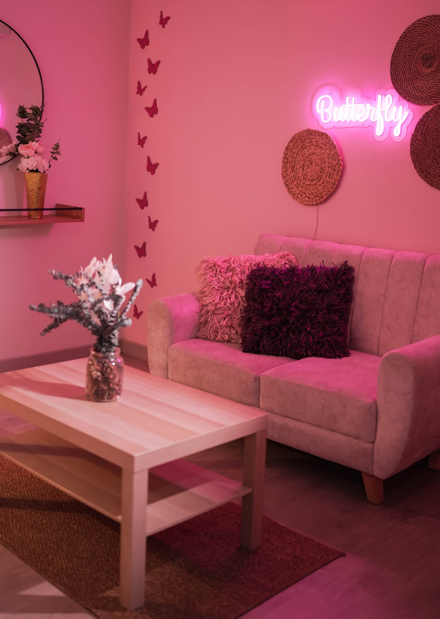 Sala de contenido lounge rosa con sofá blanco y letrero de neón
