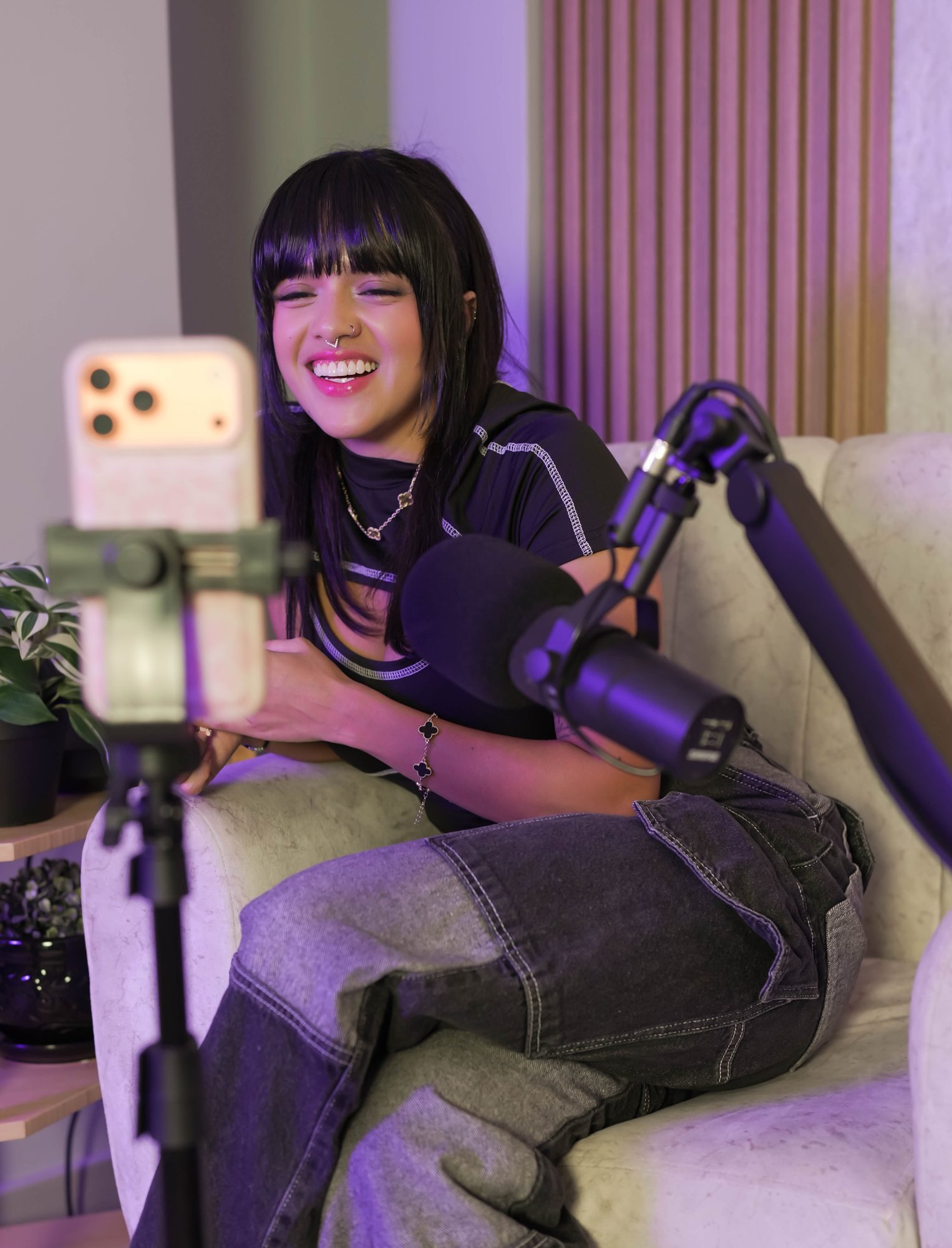 Configuración de grabación en sofá de podcast con micrófono boom y trípode para teléfono